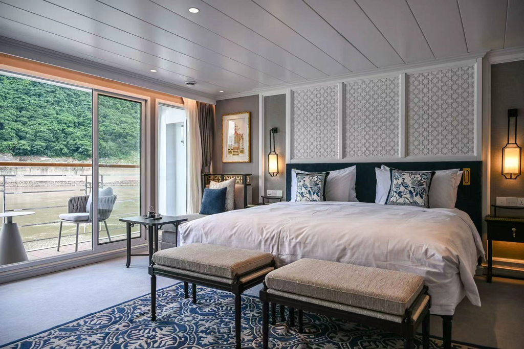 Spacious luxury suite aboard the Yangzi Explorer featuring elegant interiors and panoramic Yangtze River views
