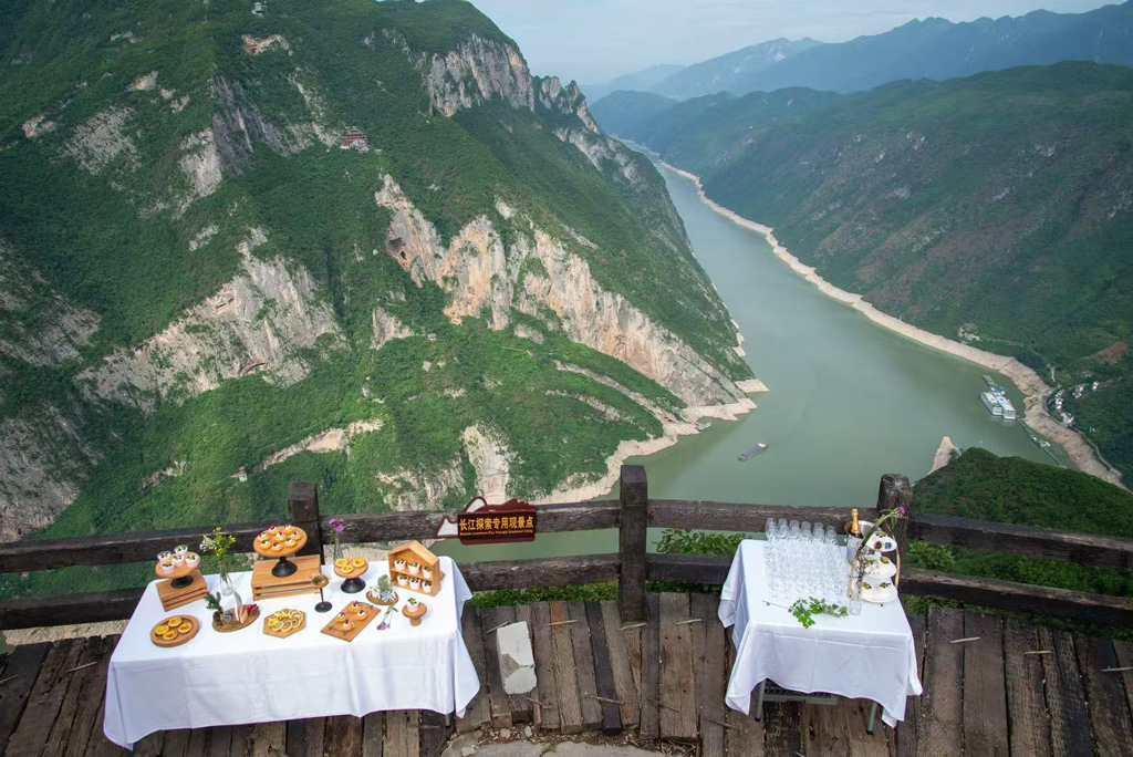 Guests enjoying a scenic cliffside dining experience overlooking the Three Gorges along the Yangtze River